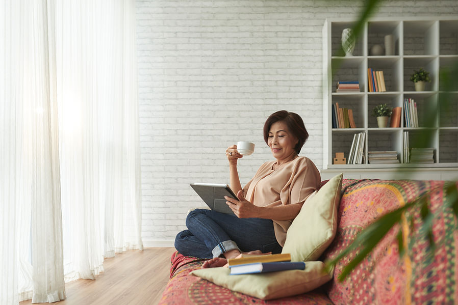 Asian lady watching a tablet at home