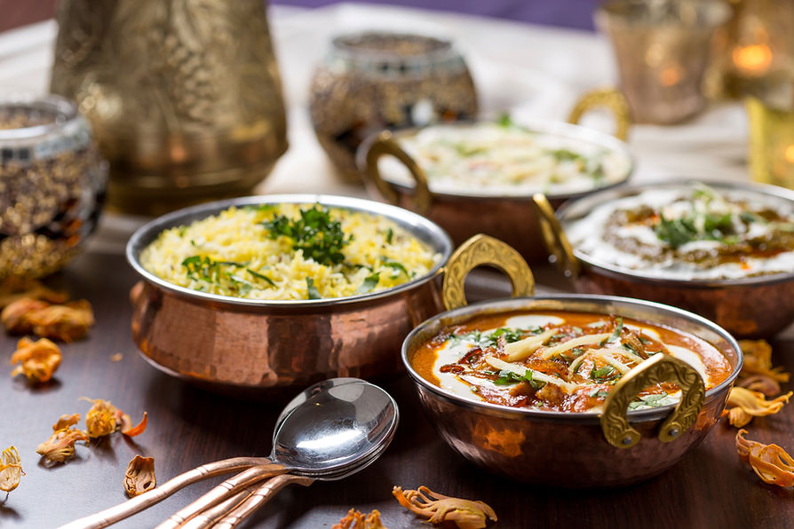 Freshly prepared Indian curries in traditional balti bowls with basmati rice