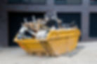 Yellow skip filled with mixed household and construction waste