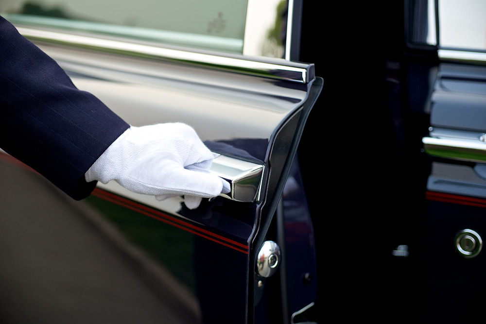 Chauffeur opens the door to car