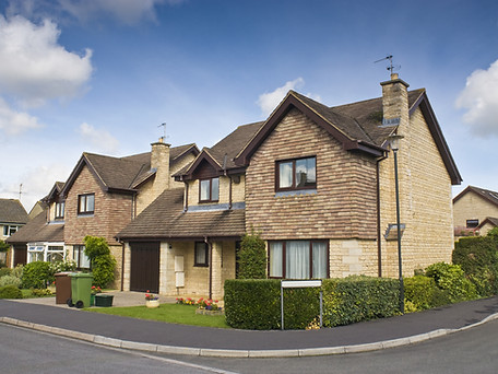 Newly built homes and gardens against a clear blue summers sky