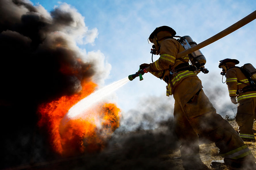 Firefighters in a fire protection suit wearing firefighter helmet with breathing device an