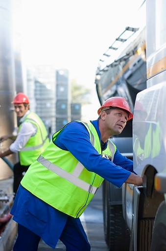 Workers filling trucks with fuel