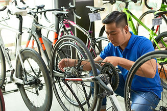 Asian man reattaching a bike chain in a bike shop
