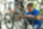 Asian man reattaching a bike chain in a bike shop