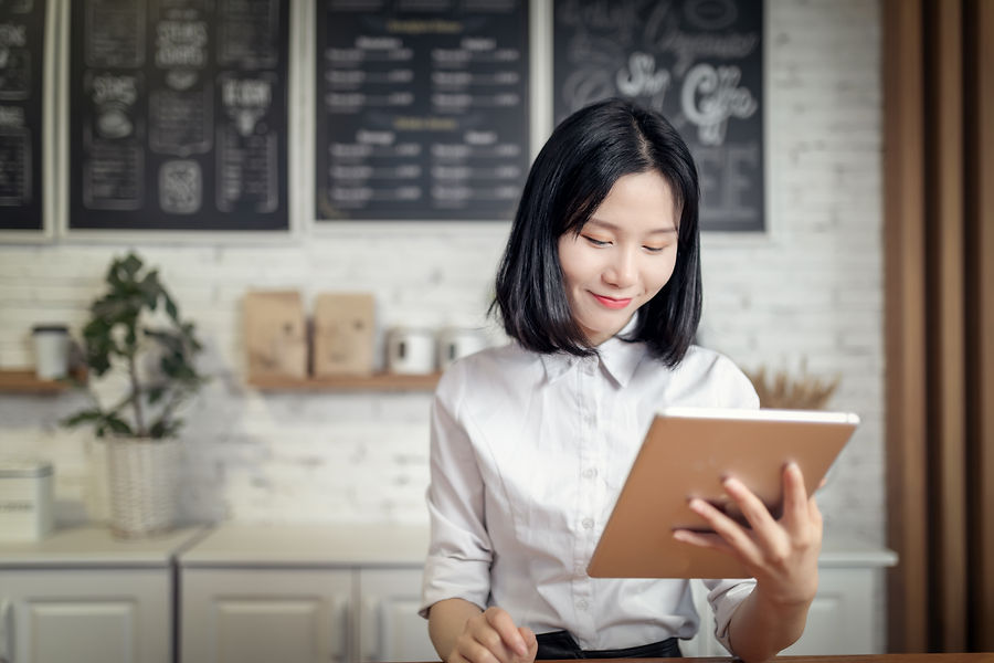 Asian woman using a tablet in a cafe