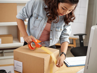 A woman packing up her product for shipping