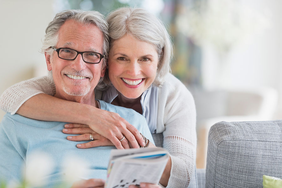Elderly woman warmly hugging elderly man, showing love and affection