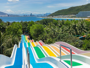colorful water slides over palm trees and a sunny summer vacation setting