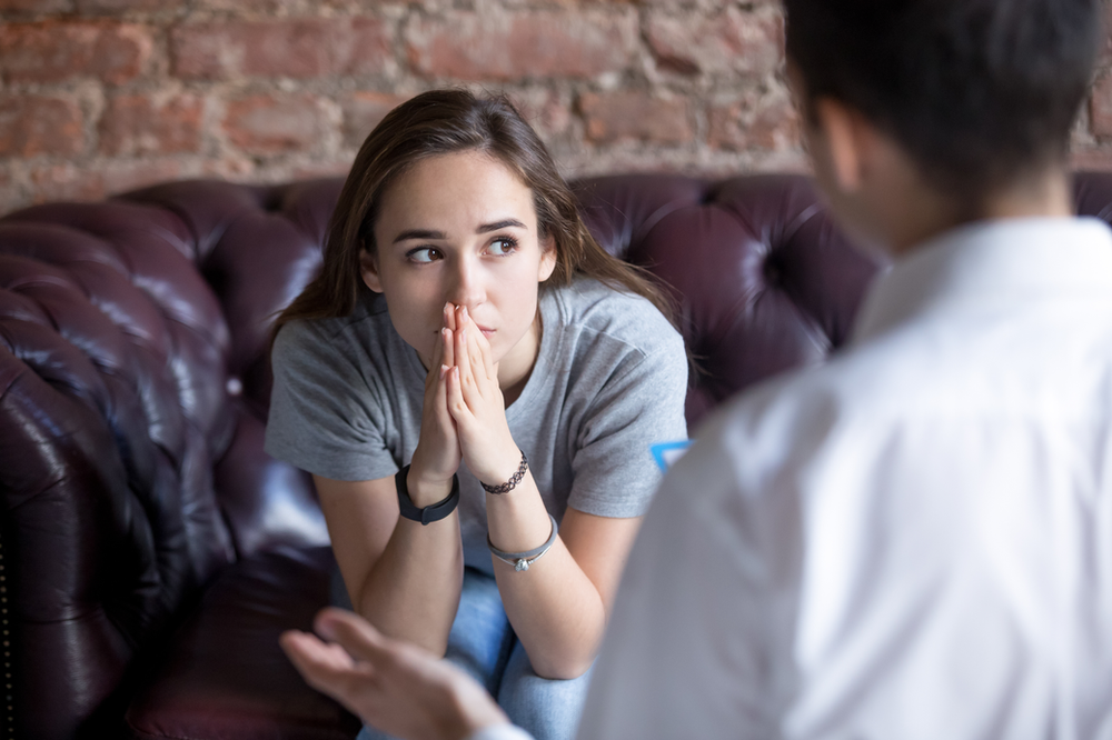 young teenage girl sitting on a coach in a therapy session