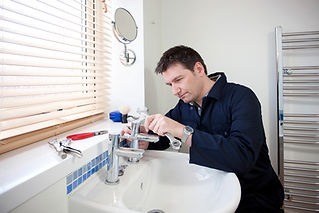 A plumber fixing a tap