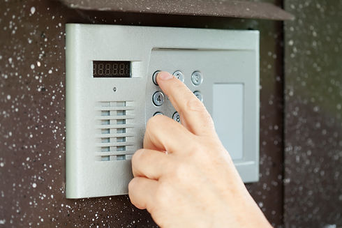 Human finger pushing button of house intercom