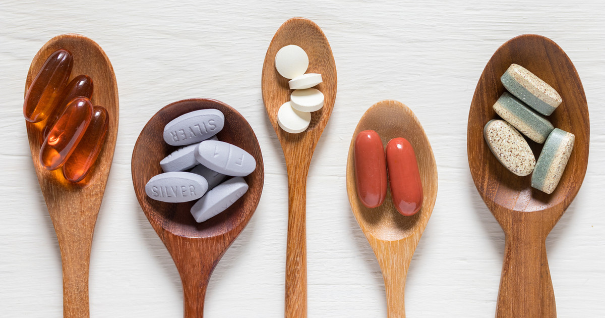 A selection of common dietary supplements alongside healthy whole foods, highlighting that supplements complement rather than replace a balanced diet.
