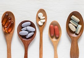 A selection of common dietary supplements alongside healthy whole foods, highlighting that supplements complement rather than replace a balanced diet.