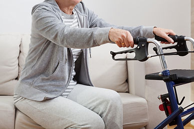 Disabled elder person standing up and holding on walker