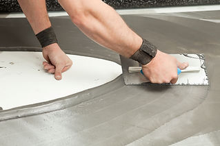 Worker using a trowel to apply mortar on a floor