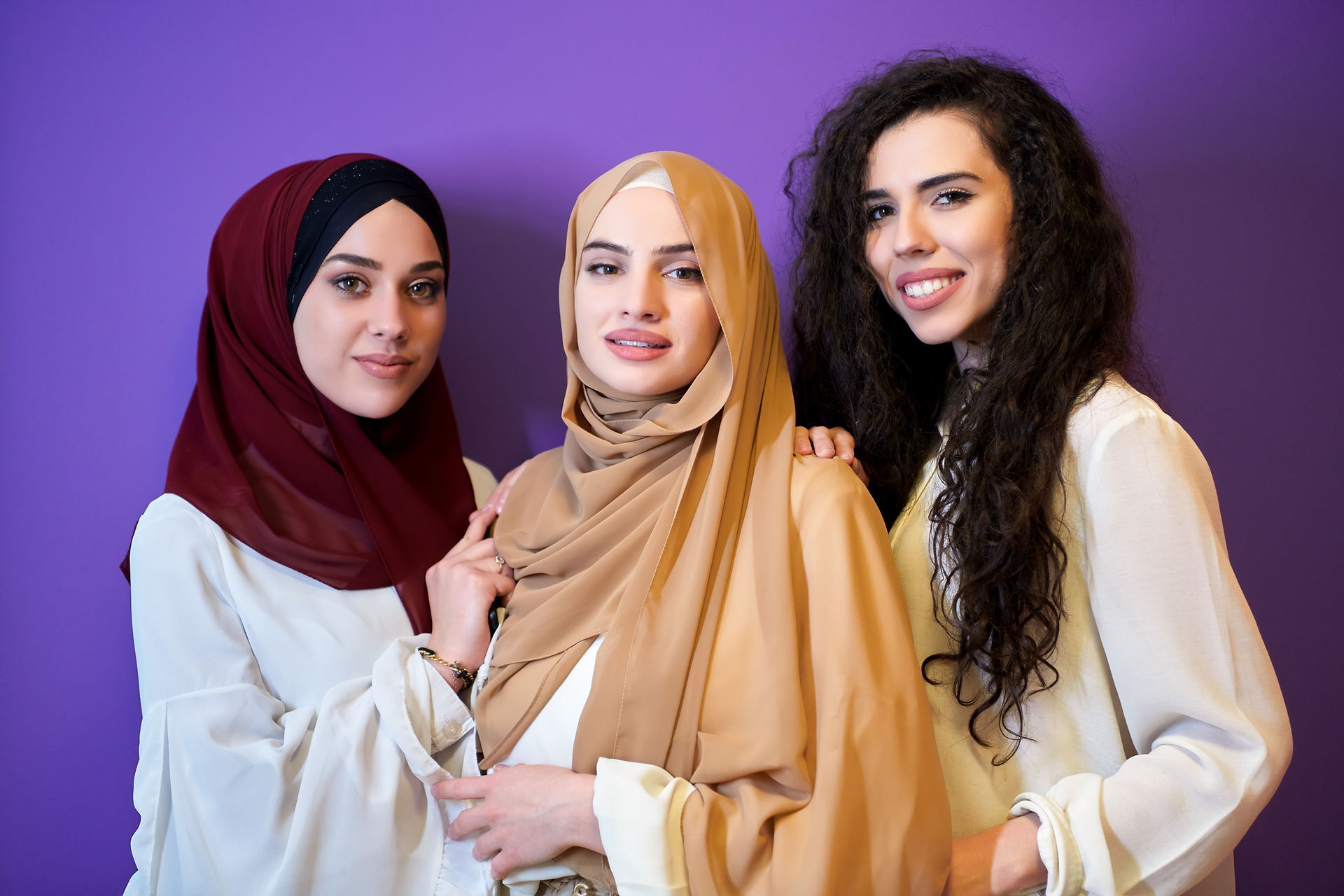 Three mothers looking at the camera with a purple background
