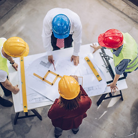 Construction workers and architects working on construction site