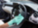 close-up image of a person's hand while cleaning car's steering wheel