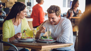 A smiling couple eating in a restaurant