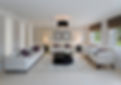 Modern living room with white sofas, purple cushions, dark coffee table, and black drum pendant light