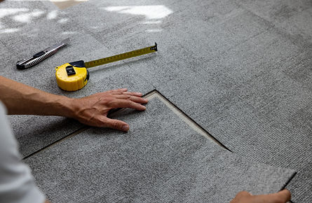 Close-up of hands installing carpet tiles