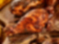 Close-up of a juicy, grilled chicken drumstick coated in a rich, dark seasoning