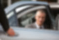 Chauffeur opening car door for businessman