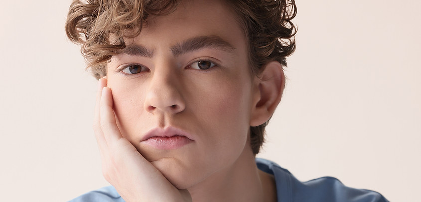 teenage boy with head in hand