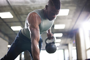 Man exercising with kettlebells in gym