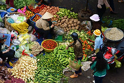 People sell and buy vegetables at open air market in Vietnam