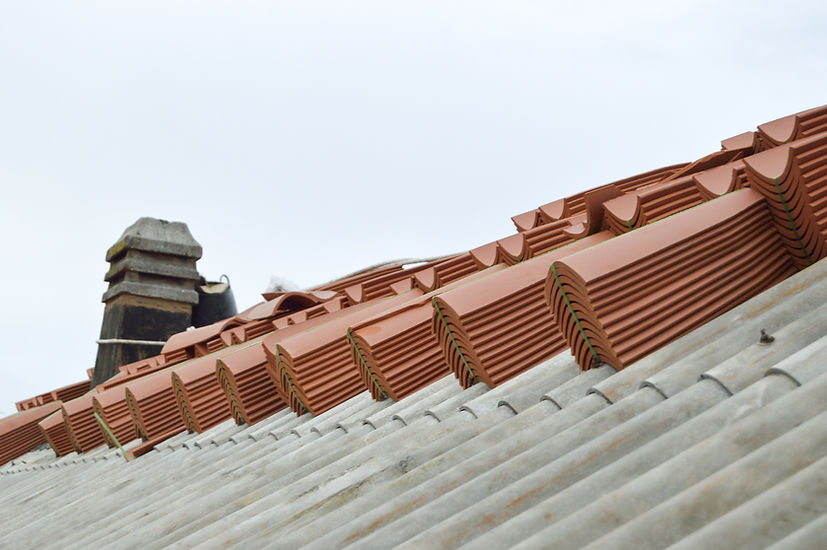 Stacks of terracotta roof tiles neatly arranged on a rooftop