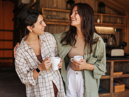 Two friends relaxing and smiling and having coffee