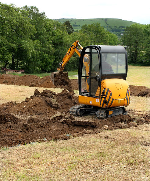 Man operating a mini digger in a field
