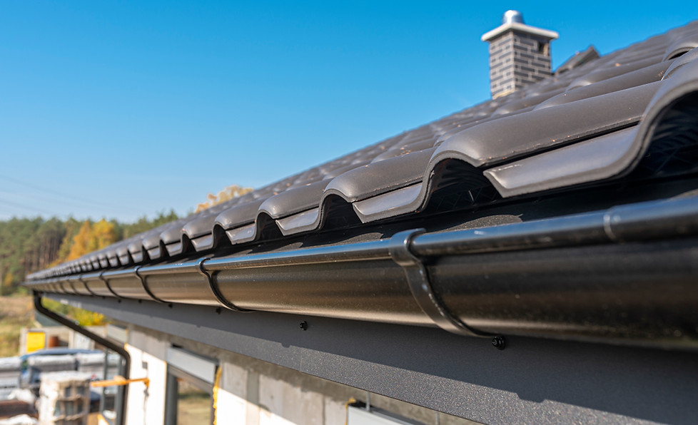 Roof and gutter against a blue sky