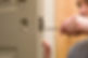 A worker replacing an entry door latch after a burglary attempt