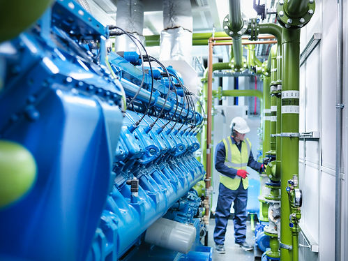 Worker with gas fired generator in gas fired power station