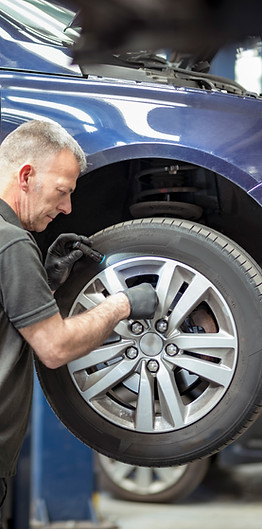 Engineer checking brakes in car service centre