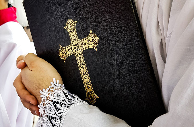 Sacerdote que sostiene el libro