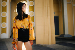 A girl in yellow shirt and black shorts.