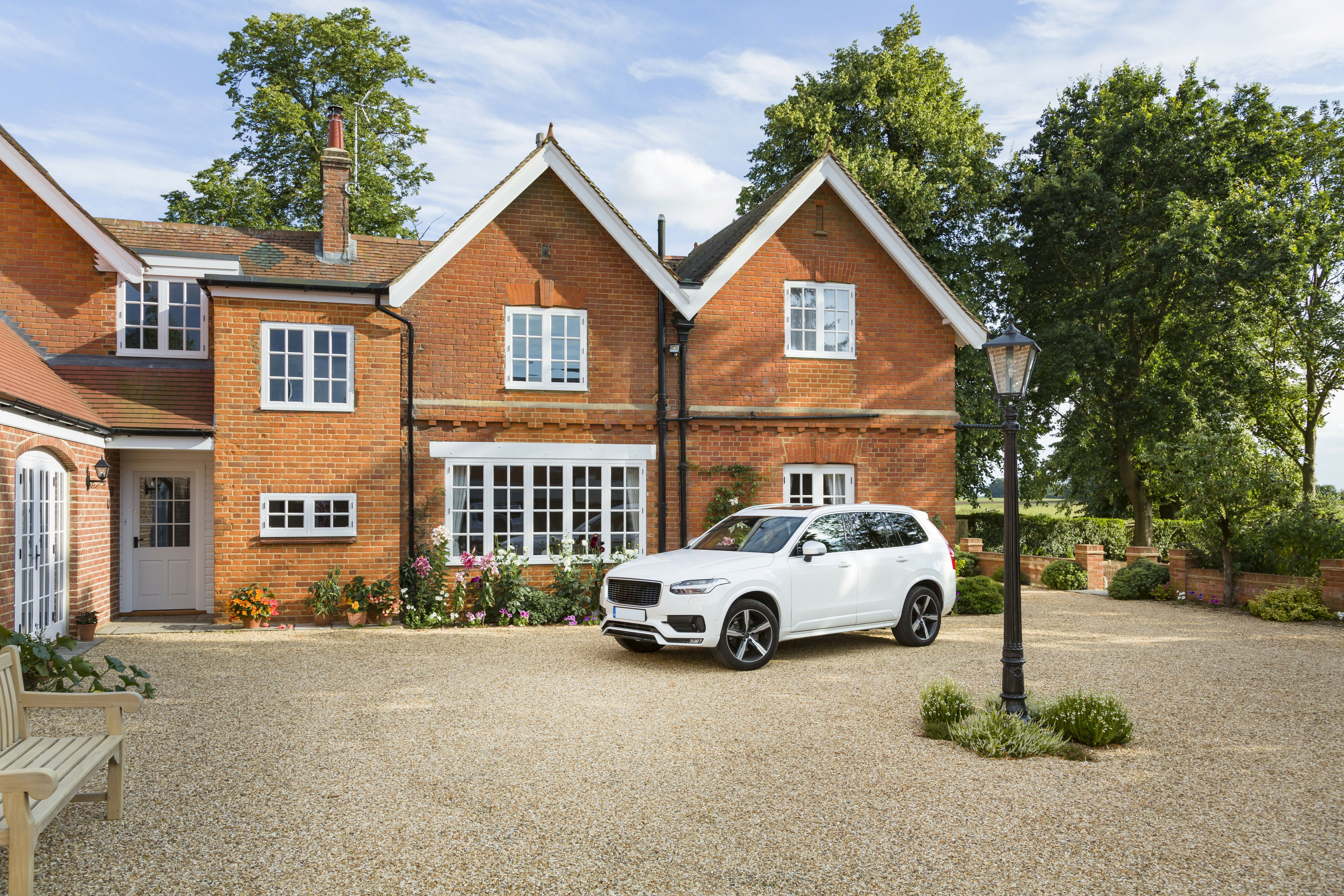 Car parked on a driveway outside a brick house