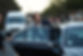Driver assisting businessman into cab, at dusk