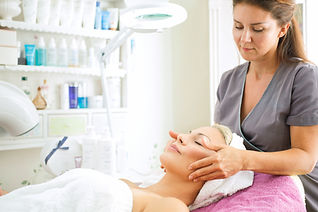A clinician applying a calming topical treatment to a female patient face