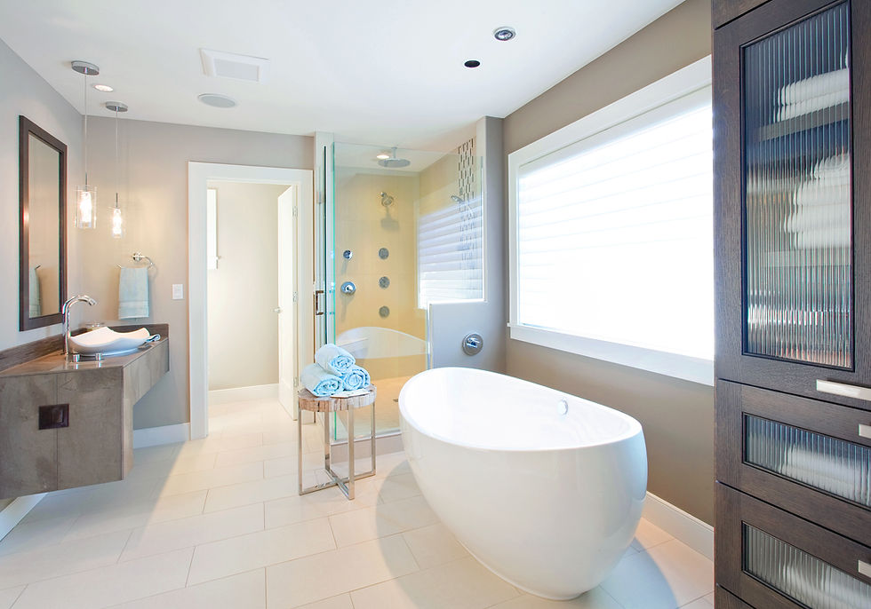 Modern bathroom with a freestanding white tub, glass shower, and large window