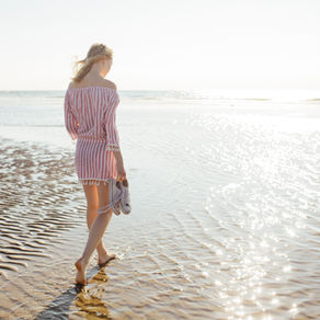 Woman walking along sunny beach