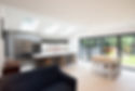 A general view of a modern fitted grey kitchen dining area with white walls, sky light win