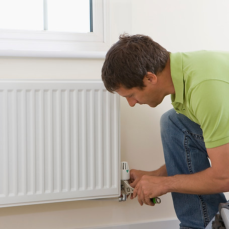 Handyman fixing radiator