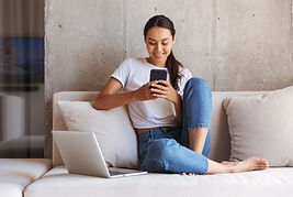 Woman sitting on a couch looking at her cell phone