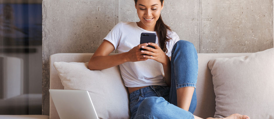 Jeune femme devant son portable regardant son cellulaire