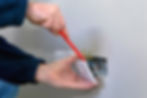 Electrician from Signature Maintenance Group fixing a wall socket.